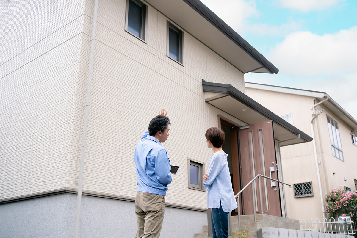 外壁の確認をする施主と作業員