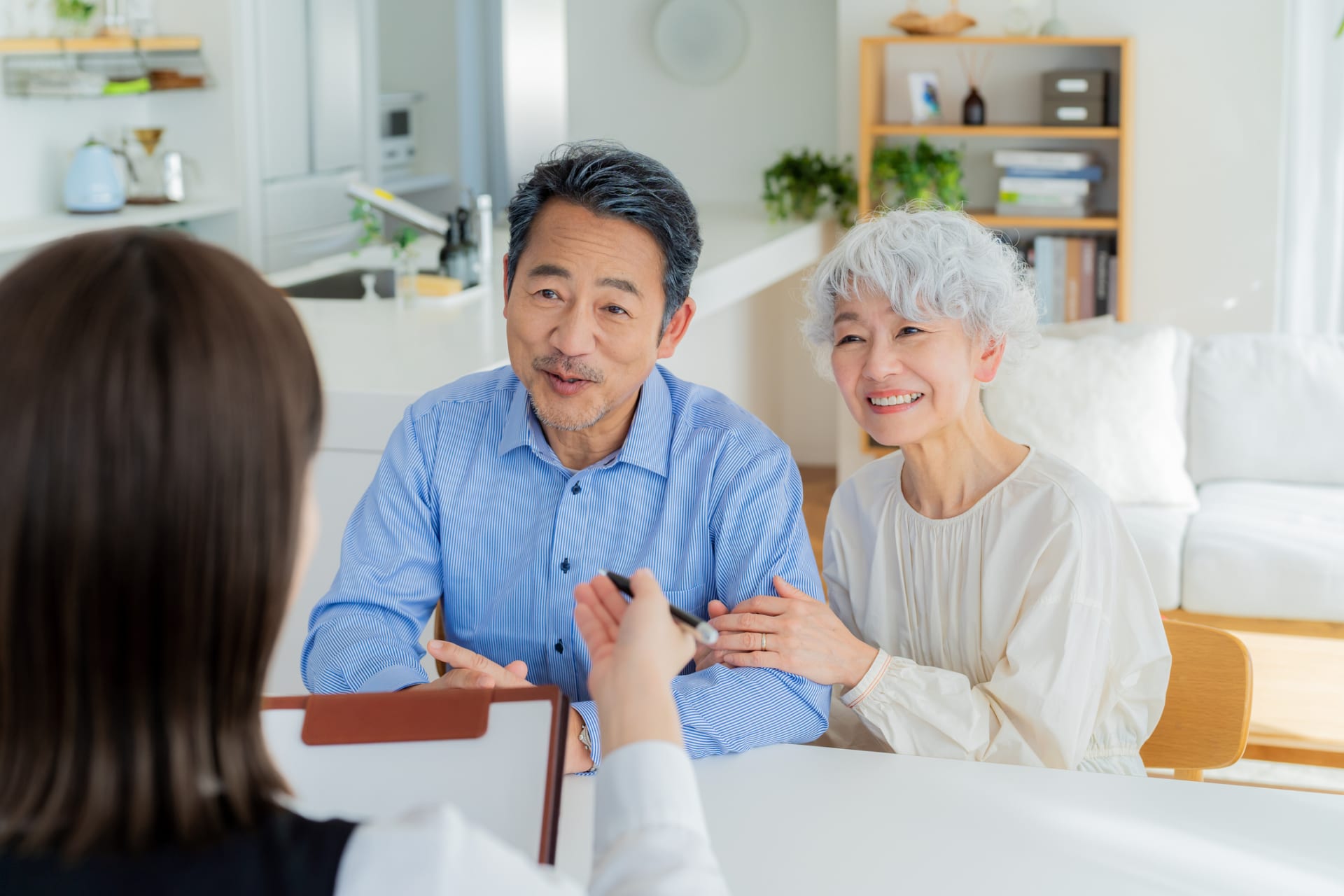 商談中のシニア夫婦と担当者。笑顔で話し合う様子。